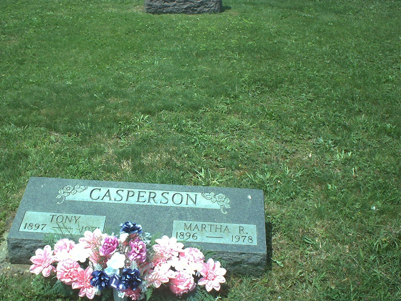 Color photograph of the Casperson grave marker for Tony, 1897–1971, and Martha R., 1896–1978, with flowers laid in front.